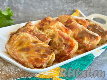 Форму с готовым блюдом достать из духовки. Нежные, вкусные, сочные голубцы из молодой капусты вместе с томатным соусом, в котором они запекались, разложить по тарелкам и&nbsp;в горячем виде подать к столу.&nbsp;