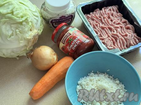 Подготовить продукты для приготовления голубцов из молодой капусты в духовке. Рис промыть водой, затем выложить в кастрюлю с кипящей подсоленной водой, перемешать, снова дать воде закипеть, уменьшить огонь и отварить рис до готовности (ориентировочно в течение минут 20-25), затем откинуть рис на сито, лишней воде дать стечь. При желании можно использовать и грамм 100 риса, оставшегося с обеда или ужина. Фарш я взяла покупной из свинины, но можно приготовить фарш и в домашних условиях, пропустив кусочки любого мяса через мясорубку.&nbsp;Лук и морковь почистить.
