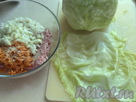 В миску с фаршем, рисом и морковкой добавить мелко нарезанный лук, посолить, приправить специями (в качестве специй я использовала соль, смешанную с чесноком и зеленью), хорошо перемешать и начинка для голубцов из молодой капусты будет готова. Острым ножом срезать утолщенную часть у основания размягчённых листов капусты.