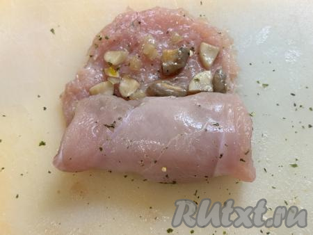 Начиная с одной из более узких сторон мяса, свернуть филе с грибной начинкой в плотный рулетик.