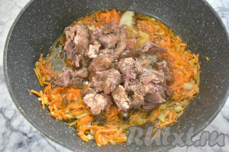 В сковороду с обжаренными овощами выкладываем тушёнку, предварительно убрав с мяса жир.
