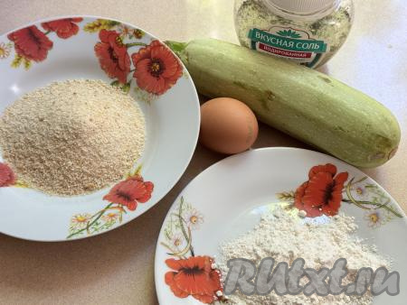 Подготовить продукты для приготовления кабачков в панировке в аэрогриле. Для этого блюда лучше всего брать молодые кабачки с мелкими семечками. Тонкую кожицу у молодых кабачков можно не срезать. Достаточно будет хорошо вымыть кабачок и отрезать кончики с двух сторон. Но если вы возьмёте кабачок с жёсткой кожурой, тогда её нужно срезать, крупные семечки нужно будет удалить.