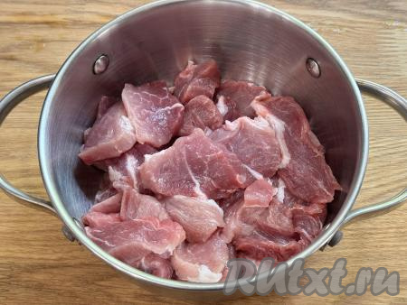 В кастрюлю с толстым дном выложить кусочки свинины.&nbsp;