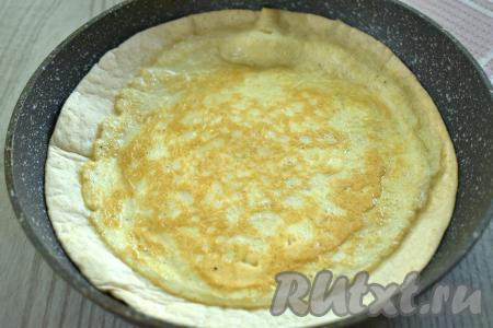 Аккуратно переворачиваем лепёшку с яйцом на сковороде. Для удобства я переворачивала лепёшку с яйцом с помощью большой плоской тарелки, для этого накрыла сковороду тарелкой и быстро перевернула, лепёшка с яйцом оказались на тарелке, а затем с тарелки переложила тортилью с яйцом уже на сковороду яйцом верх.