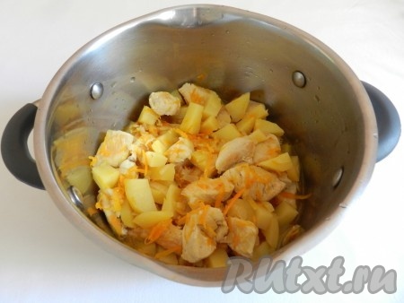 Обжаренные кусочки куриного мяса с морковкой и луком переложить в кастрюлю. Картошку очистить, нарезать кубиками и тоже выложить в кастрюлю, налить воду так, чтобы она только покрывала мясо с овощами, поставить на огонь, дать закипеть и уменьшить огонь. Тушить на маленьком огне под крышкой до готовности картофеля (минут 15-20).
