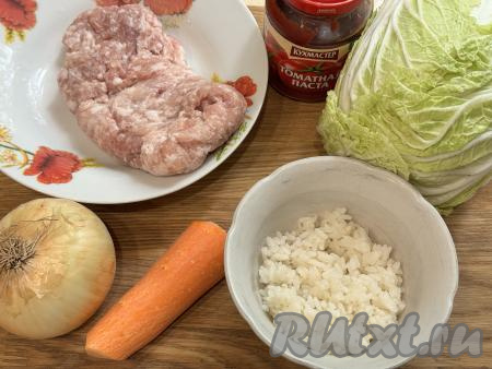 Подготовить продукты для приготовления голубцов из пекинской капусты в аэрогриле. Рис промыть водой, затем выложить его в кастрюлю с кипящей подсоленной водой, перемешать, снова дать воде закипеть, уменьшить огонь и отварить рис до готовности (ориентировочно в течение 20-25 минут с момента закипания воды). Сварившийся рис откинуть на сито, чтобы стекла лишняя вода, дать остыть. При желании можно специально не варить рис, а взять 80-90 грамм&nbsp;варёного риса, оставшегося с обеда или ужина. Для получения фарша нужно пропустить через мясорубку кусочки любого мяса (я взяла свинину), при желании можно использовать и покупной фарш.