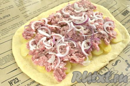 На слой из картошки равномерно выкладываем мясной фарш. Поверх мяса раскладываем очищенный лук, нарезанный на тонкие полукольца. Перчим начинку по вкусу.