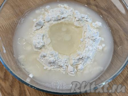 В миску с мукой и солью влить 100 миллилитров воды комнатной температуры и растительное масло.