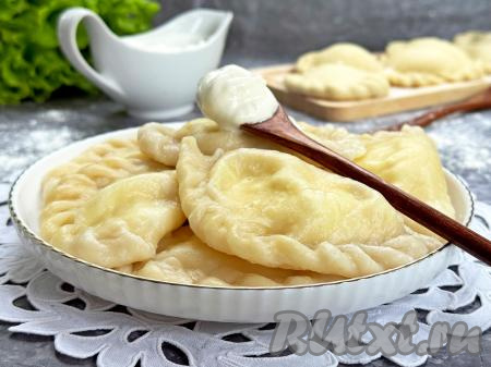 Готовые вареники с помощью шумовки достать из кастрюли, выложить на тарелку и в горячем виде подать к столу, дополнив сметаной.