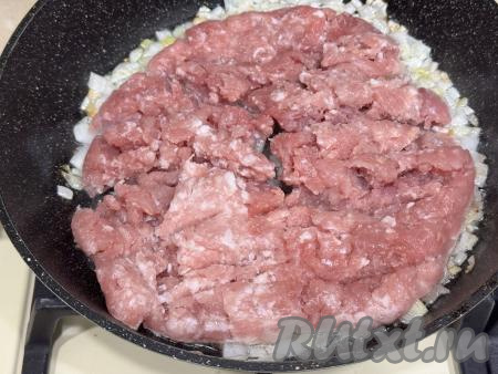 В сковороду с обжаренным луком добавить мясной фарш, перемешать.