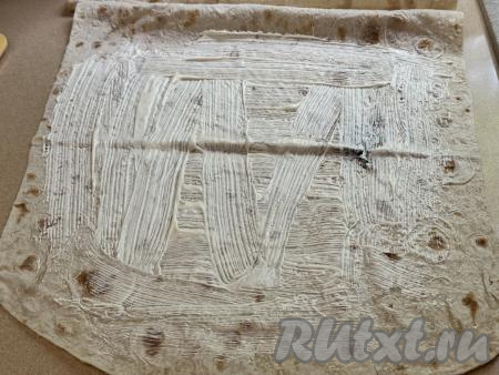 Расстелить на рабочей поверхности лист лаваша. Равномерно смазать лаваш 2-2,5 столовыми ложками майонеза, отступая от краёв лаваша по 1-1,5 сантиметра.&nbsp;