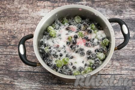 Засыпать смородину и крыжовник сахаром, аккуратно перемешать, стараясь не мять сильно ягоды и оставить в тёплом месте на 1-2 часа. В течение этого времени можно 1-2 раза аккуратно перемешать содержимое кастрюли, распределяя сахар по ягодам. Смородина выделит немного сока.