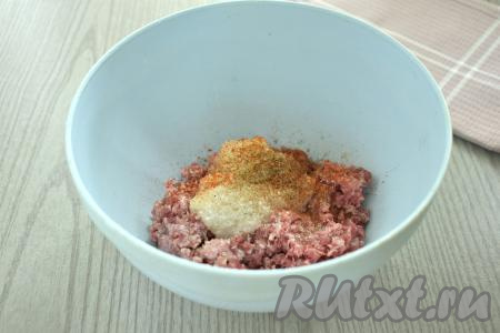 Для получения начинки для рулетиков из кабачков можно взять кусочки любого мяса (у меня - свинина и говядина) и пропустить через мясорубку в миску. Можно использовать и покупной фарш. В миску с фаршем добавляем пропущенный через мясорубку (или натёртый на крупной тёрке) лук,&nbsp;солим, посыпаем специями (у меня - чёрный молотый перец и паприка).