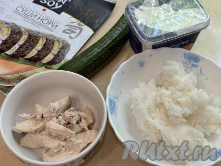 Подготовить продукты для приготовления ленивых суши с курицей. Для формирования ленивых суши лучше всего взять рис для суши или обычный круглозёрный (круглый) рис. Рис хорошо промыть водой. В кастрюле вскипятить 300 миллилитров подсоленной воды, выложить промытый рис, перемешать, ещё раз дать воде закипеть, уменьшить огонь до минимума, отварить рис до готовности (ориентировочно в течение 20-25 минут, рисинки должны стать мягкими), затем откинуть рис на сито, лишней воде дать стечь. Остывший рис при желании можно заправить рисовым уксусом. Куриное филе нужно заранее отварить в подсоленной воде в течение 25 минут с момента закипания воды, затем дать мясу остыть. 