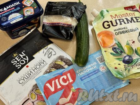 Подготовить продукты для приготовления онигири с крабовыми палочками и огурцом. Крабовые палочки разморозить при комнатной температуре. Огурец вымыть. Для формирования онигири лучше всего взять рис для суши или обычный круглозёрный (круглый) рис.