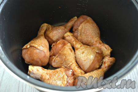 Чашу мультиварки смазываем растительным маслом, выкладываем замаринованные куриные ножки. Слегка смазываем ножки сверху соевым соусом, в котором они мариновались.