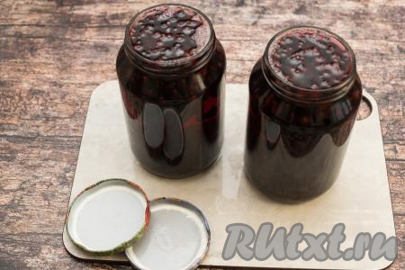 Убрать кастрюлю с огня, разлить горячий сироп по банкам с чёрной смородиной и базиликом, заполняя баночки доверху.