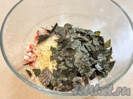 Листья нори нарезать кухонными ножницами на мелкие кусочки и тоже добавить в миску, перемешать столовой ложкой.