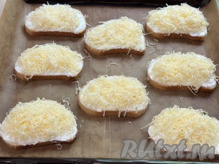На каждый бутерброд, смазанный творожным сыром, выложить часть натёртого сыра.