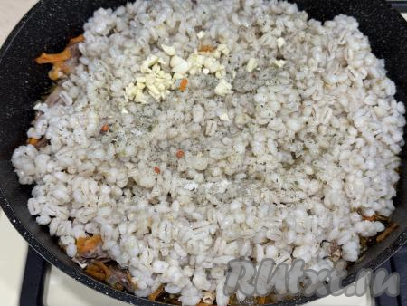 Добавить соль по вкусу и пропущенный через пресс чеснок. Перемешать сердечки с перловкой, накрыть крышкой и дать 3 минуты потомиться на минимальном огне. За это время 1-2 раза можно блюда перемешать. Затем выключить огонь и можно подавать блюдо к столу.