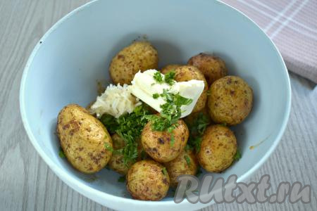 Готовый молодой картофель, запечённый в кожуре в аэрогриле, можно сразу подавать к столу. А я решила выложить его вначале в глубокую миску, добавила сливочное масло, мелко нарезанную зелень (у меня - петрушка), очищенный и пропущенный через пресс чеснок.