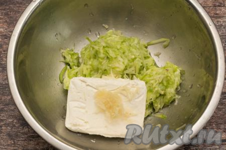 В миску к кабачковой массе добавить творог, а также очищенный и натёртый на мелкой тёрке чеснок. Если творог у вас сильно крупинчатый, тогда предварительно можно перетереть его через сито, чтобы он стал однородным.