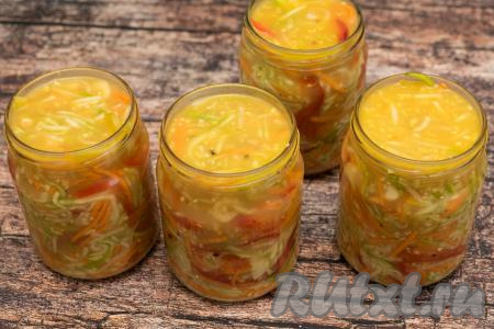Разложить корейский салат по банкам, стараясь утрамбовывать овощи ложкой поплотнее, чтобы не было воздушных мешков. Заполнить банки с овощами до самого верха жидкостью, оставшейся в кастрюле после маринования овощей. Я утрамбовывала овощи в банки очень плотно, поэтому жидкости было более, чем достаточно, чтобы до самого верха заполнить баночки. Сразу прикрыть банки прокипячёнными крышками. Кабачки с болгарским перцем и морковью поместились у меня в 4 банки объёмом по 500 миллилитров.