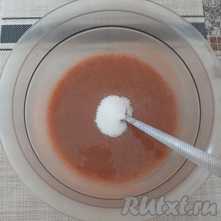 В миску с получившимся пюре из крыжовника добавить сахар по вкусу, перемешать столовой ложкой и оставить на несколько минут, чтобы сахар весь растворился.