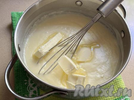 В кастрюлю с горячим заварным кремом добавить размягчившееся сливочное масло, нарезанное на кусочки.
