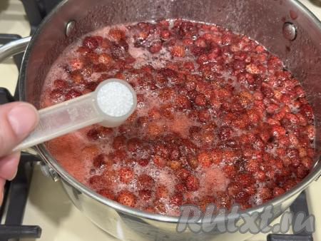 В закипевшее земляничное варенье добавить лимонную кислоту, перемешать. Лимонная кислота не даёт размороженной землянике в процессе варки превратиться в пюре, сохраняя целостность ягод. Кроме того, земляника в процессе варки может потемнеть, в этом случае варенье не будет ярким, аппетитным, а лимонная кислота сохраняет яркие краски земляники, поэтому варенье получается красивым. 