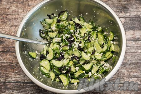 Перемешать огурцы с творогом, чесноком и зеленью, посолить салат по вкусу.