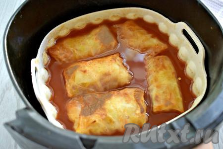 Ставим чашу с замороженными голубцами в аэрогриль. Включаем аэрогриль, выставив температуру на 180 градусов, а время - на 35 минут. Через каждые 10 минут чашу нужно доставать из аэрогриля и поливать голубцы соусом, в котором они томятся. Я готовила замороженные голубцы в аэрогриле мощностью 1400 Ватт с 1 ТЭН-ом, указанного времени вполне хватило, чтобы голубцы полностью приготовились.