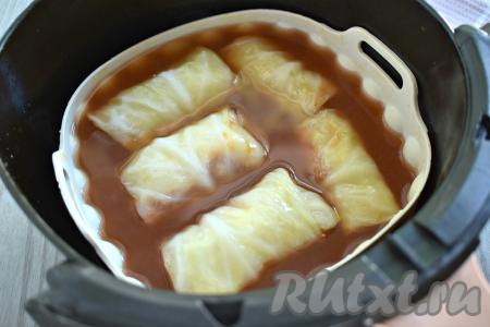 Форму с замороженными голубцами ставим в чашу аэрогриля. Заливаем голубцы томатным соусом, он должен слегка покрывать голубцы. Если соуса недостаточно, просто добавьте ещё немного горячей кипячёной воды и, если нужно, подсолите по вкусу.