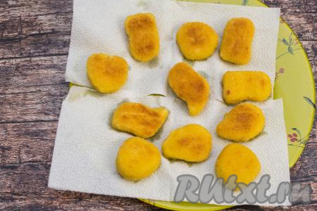 Готовые наггетсы переложить со сковороды на бумажные салфетки, чтобы убрать излишки масла.