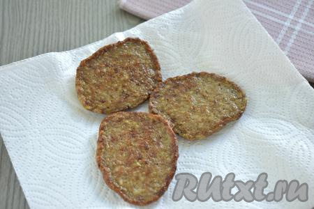 Готовые оладьи из куриной печени и кабачка вначале со сковороды выкладываем на бумажное полотенце, чтобы убрать лишнее масло, а после этого перекладываем на тарелку для подачи. Периодически перемешивая тесто, постепенно жарим все оладушки. Из предложенного количества ингредиентов у меня получились 14 печёночно-кабачковых оладий.