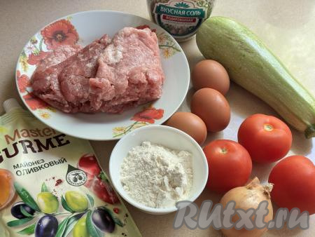 Подготовить продукты для приготовления кабачкового торта с фаршем и помидорами. Мясной фарш можно приготовить из любого мяса (у меня - свинина), пропустив его через мясорубку. Можно использовать и любой покупной фарш. Помидоры вымыть. Я взяла молодой кабачок с мелкими семечками и тонкой кожицей, поэтому очищать его от кожуры и семечек не стала, только вымыла и отрезала кончики с двух сторон. Если же вы взяли кабачок с толстой кожурой, её нужно будет срезать, рыхлую мякоть с крупными семечками нужно будет удалить. Для этого торта нам потребуется 380 грамм подготовленных кабачков.&nbsp;
