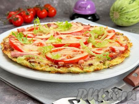 Готовую пиццу на нежной, аппетитной кабачковой основе с сочной начинкой из помидоров и колбасы переложить со сковороды на плоское блюдо&nbsp;и в горячем виде подать к столу.