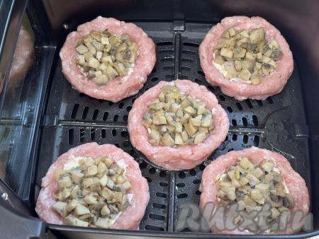Остывшую грибную начинку разделить на 5 равных частей и разложить по мясным гнёздам, смазанным майонезом.&nbsp;