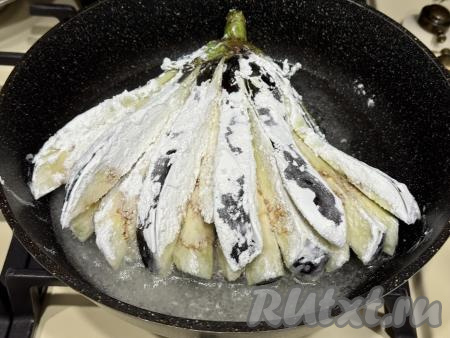 В сковороду влить достаточно большое количество растительного масла (примерно на высоту 1 сантиметр от дна сковороды), разогреть, аккуратно выложить веер из баклажана, покрытый крахмалом.&nbsp;