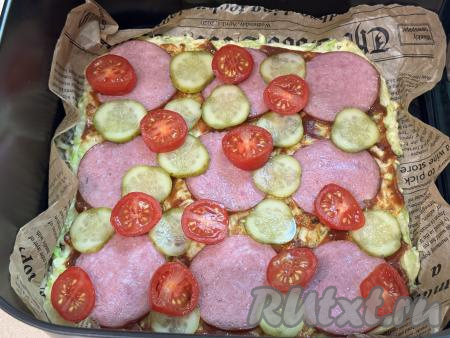 Маринованные огурец и помидоры нарезать на тонкие кружочки. Выложить помидоры и огурцы поверх будущей кабачковой пиццы.
