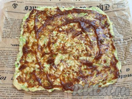 Равномерно смазать кабачковый корж кетчупом (или томатным соусом).