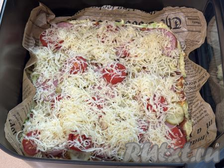 Сверху кабачковую пиццу посыпать сыром, натёртым на мелкой тёрке, поместить чашу в аэрогриль, установить температуру 180 градусов, время - 10 минут.