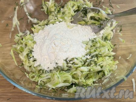 В миску с кабачковой массой всыпать 2 столовых ложки муки, перемешать.