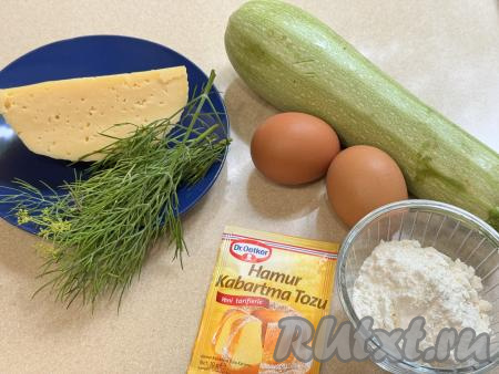 Подготовить продукты для приготовления кексов из кабачков в аэрогриле. Я использовала молоденький кабачок с тонкой кожицей и мелкими семечками, поэтому очищать от кожуры его не стала, просто обрезала кончики с двух сторон. Если вы возьмёте кабачок с толстой кожурой, её нужно будет срезать, крупные семечки нужно будет удалить. Для приготовления кексов нам потребуется 300 грамм подготовленного кабачка. Укроп промыть водой, обсушить. Чеснок почистить. Сыр можно использовать как твёрдый, так и полутвёрдый.