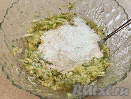 В миску с кабачковой массой всыпать весь разрыхлитель и 1 столовую ложку муки, перемешать до однородности.&nbsp;