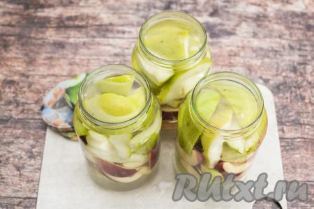 Залить банки с яблоками и грушами кипящей водой, заполняя баночки кипятком до самого верха.
