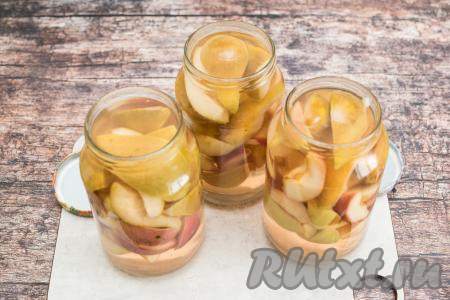 Убрать кастрюлю с огня, разлить сироп по банкам с яблоками и грушами, заполняя баночки сиропом до самого верха.