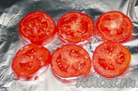 Нарезать свежие помидоры кружками и выложить в один ряд на фольге, слегка посолить.