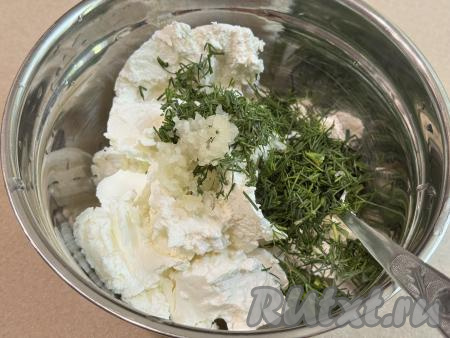 Пока кабачковый корж остывает, приготовим начинку для рулета. Для этого укроп и помидоры нужно вымыть, дать немного обсохнуть. В глубокую миску выложить творожный сыр, добавить мелко нарезанный укроп и пропущенные через пресс очищенные зубчики чеснока, подсолить по вкусу, перемешать творожную начинку для рулета до однородности.