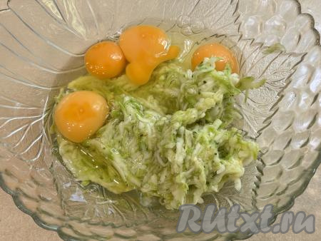 В миску с отжатой кабачковой массой добавить сырые яйца.